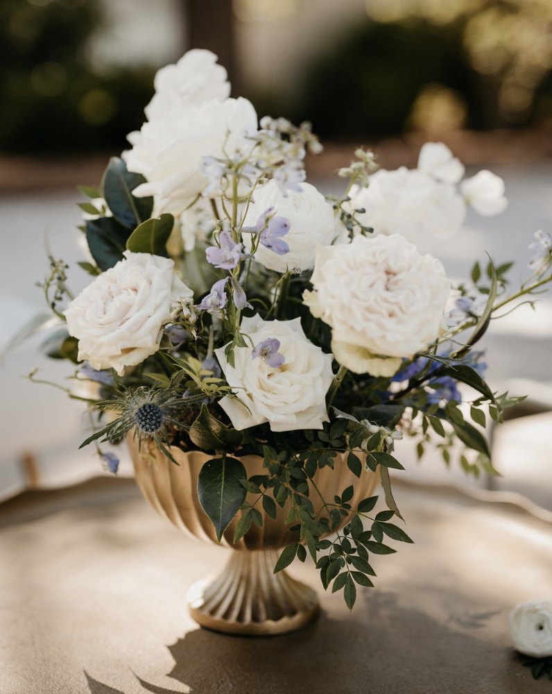 A gold compote of white garden roses, sweet peas and soft greenery